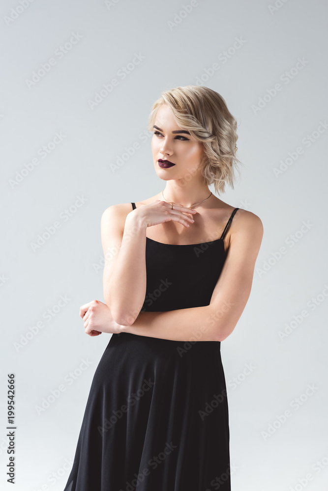 attractive blonde girl posing in elegant black dress, isolated on grey attractive blonde girl posing in elegant black dress, isolated on grey