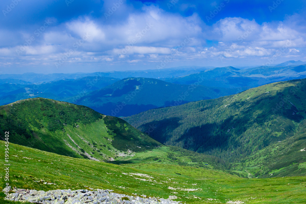 landscape of a Carpathians mountains with  grassy valley, rocky and sky