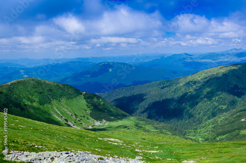landscape of a Carpathians mountains with grassy valley, rocky and sky