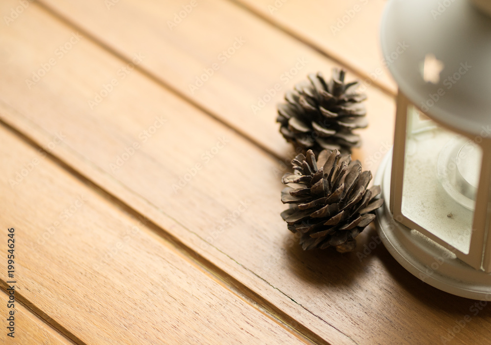 Pine cone with light a candle on wood table