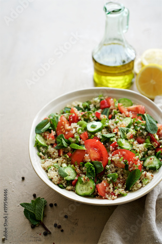Quinoa tabule salad. Cucumbers, bell peppers, tomatoes, parsley, onions, mint ingredients
 photo