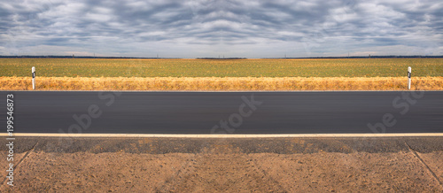 Abstract highway road in front of an agriculture field