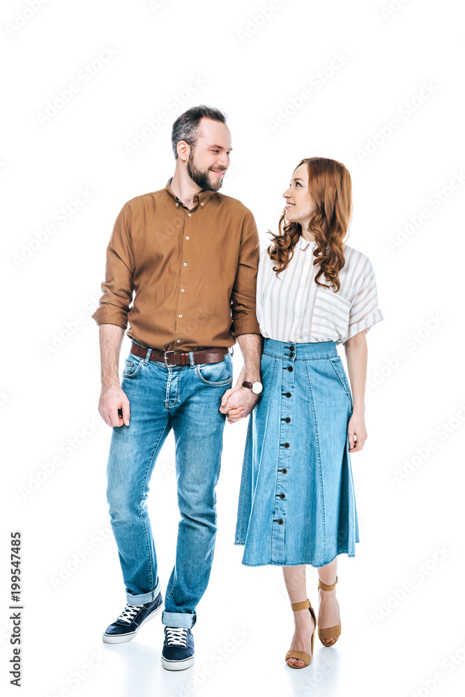full length view of happy couple holding hands and smiling each other isolated on white full length view of happy couple holding hands and smiling each other isolated on white