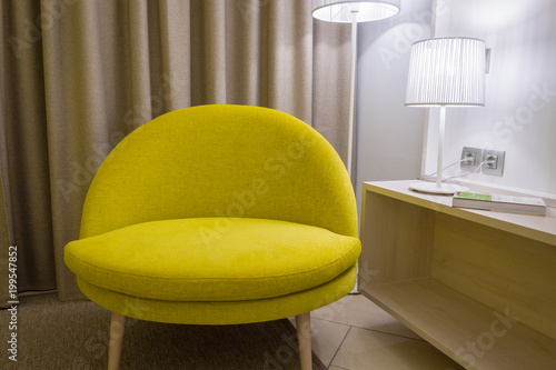 Big modern green armchair is standing in grey's room.