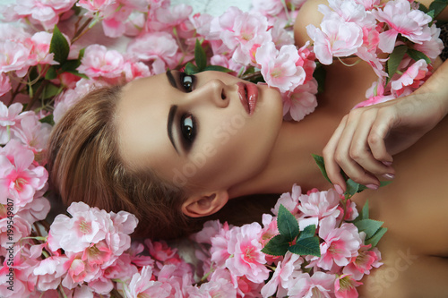 Beautiful blondie model is emotionally posing with flowers