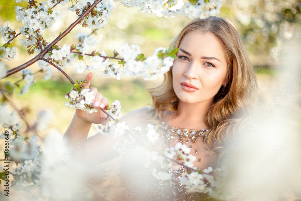 Spring. Close-up horizontal portrait of a beautiful girl near blooming tree. Artwork. Copy space
