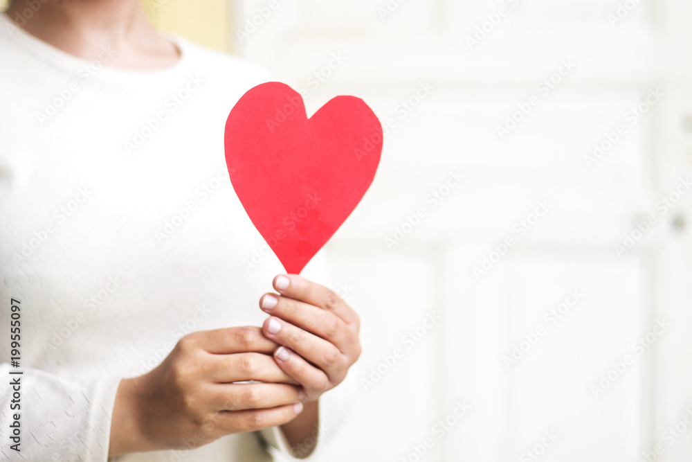 woman hand holding red paper heart shape for valentine's day