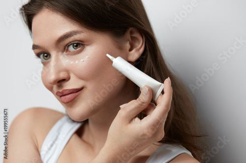 Eye Skin Care. Beautiful Woman Applying Eye Cream