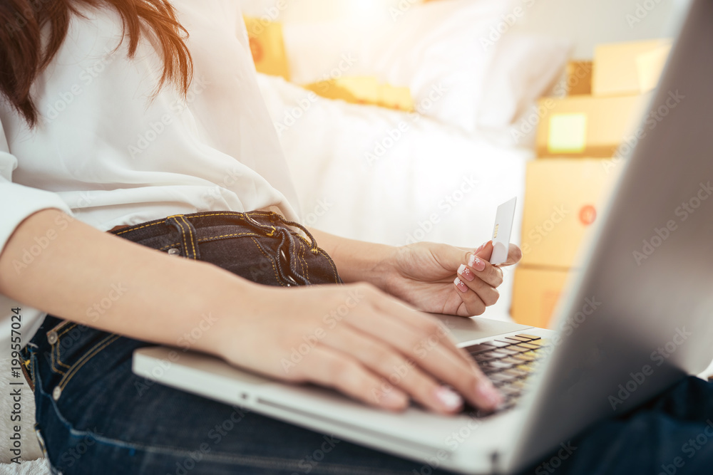 Naklejka premium Young asian girl is freelancer with her private business at home office, working with laptop, coffee, online marketing. Young woman startup her SME business.