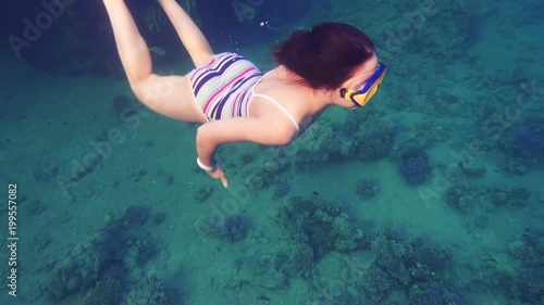 Girl dive in Red sea near coral reef