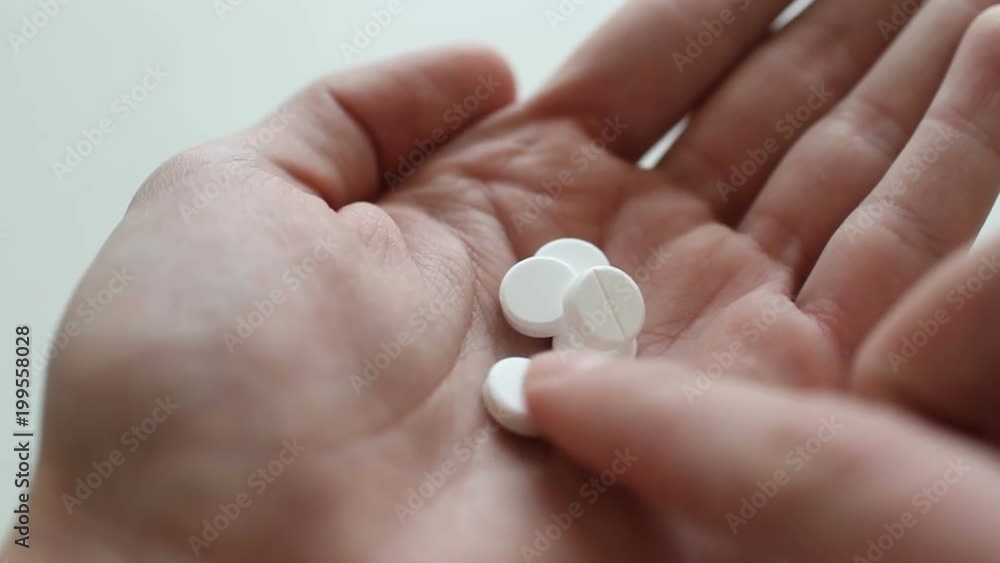 Man takes and shows pills vitamins or drugs tablets in hand from pill bottle Man takes and shows pills vitamins or drugs tablets in hand from pill bottle