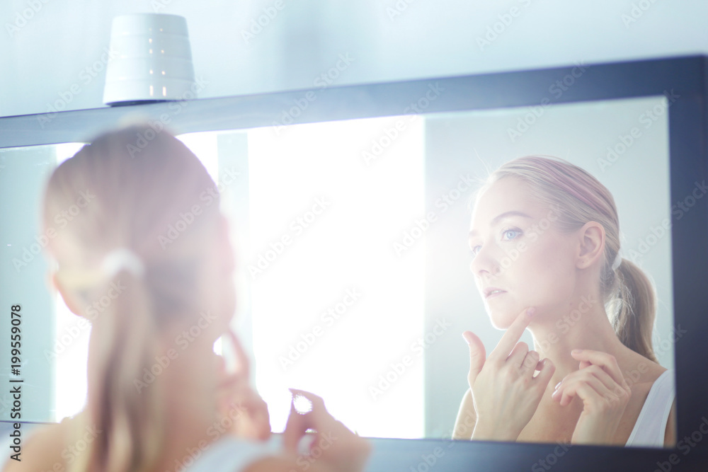 The beautiful young girl with a clean fresh skin touches with a hand a ...