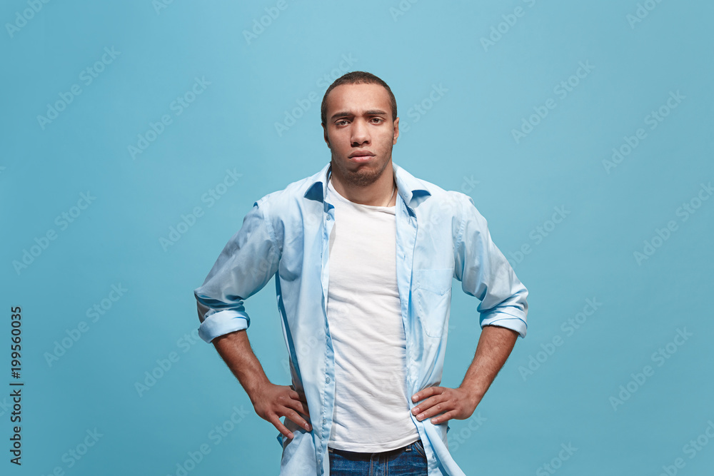 The serious businessman standing and looking at camera against studio background. The serious businessman standing and looking at camera against studio background.