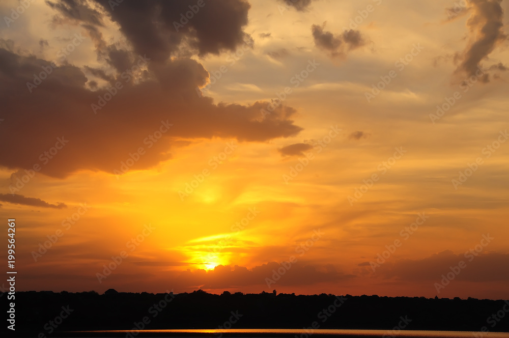 Beautiful sunset on the lake. Shiluetu shore on the background of the setting sun.
