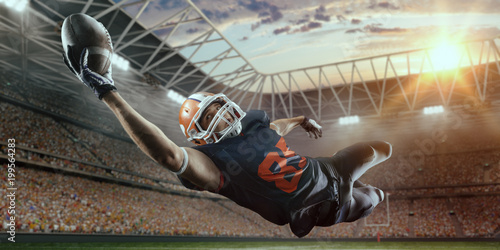 Canvas Print American football player jumps and catches the ball in flight in professional sp