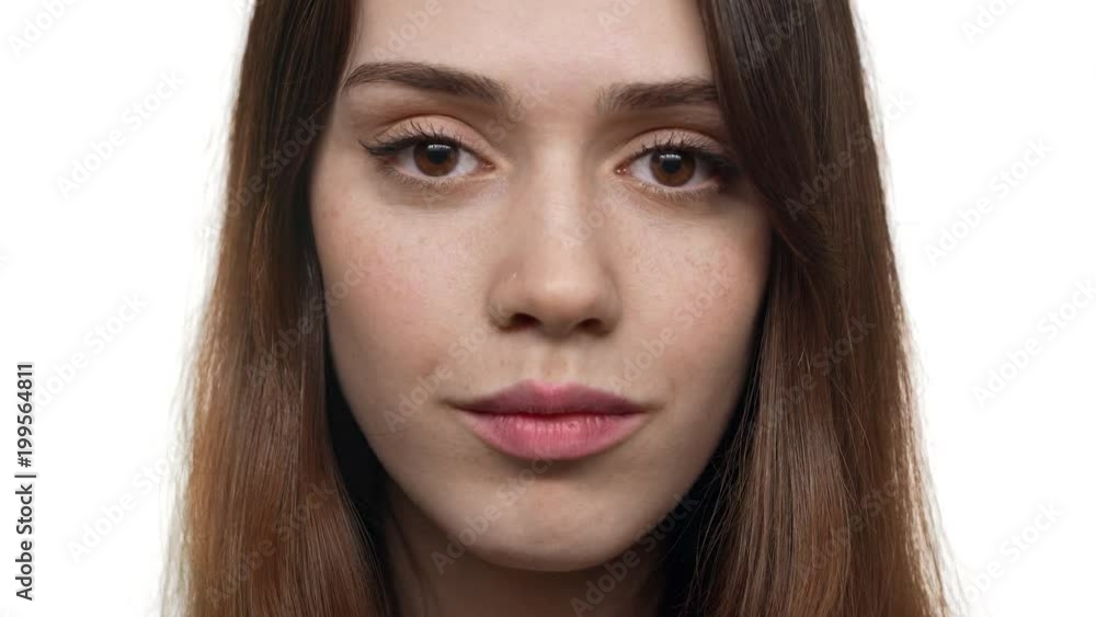 Extreme closeup portrait of european woman 20s with auburn hair and natural makeup looking on you with smile, isolated over white background. Concept of emotions