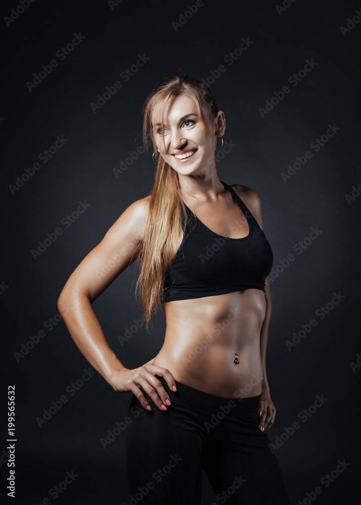 Sporty girl doing studio shot over black background Sporty girl doing studio shot over black background