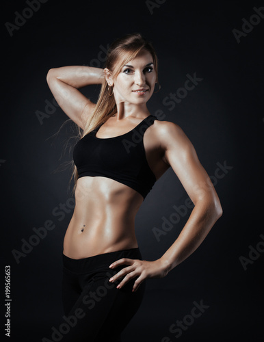 Sporty girl doing studio shot over black background © lkoimages