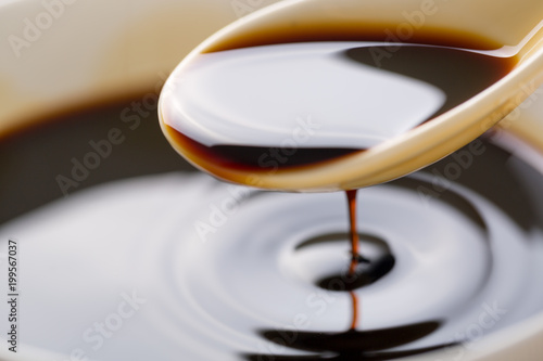 Closeup of soy sauce poured from a spoon