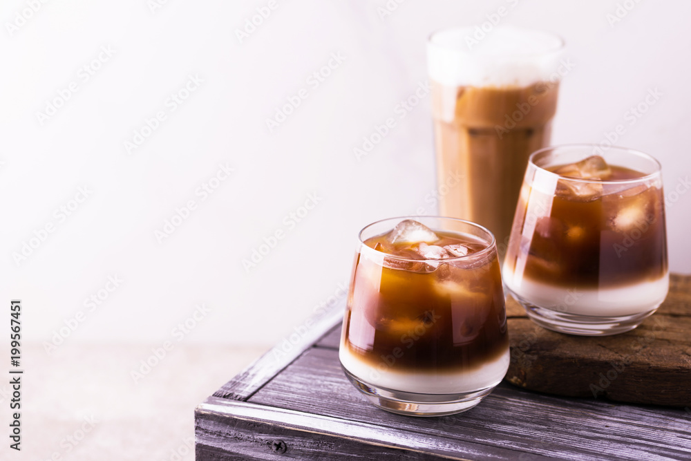 Iced coffee in glasses with milk. Black background Iced coffee in glasses with milk. Black background