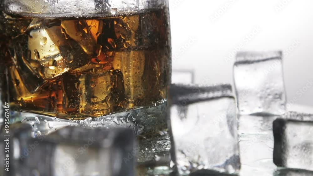 whiskey in a glass with ice on a light background in the contour light. Alcoholic beverages. video dolly whiskey in a glass with ice on a light background in the contour light. Alcoholic beverages. video dolly