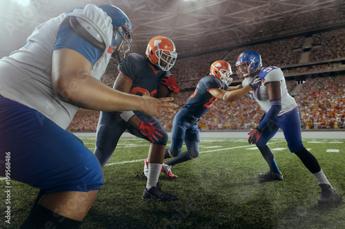 American football players preforms an action play in professional sport stadium