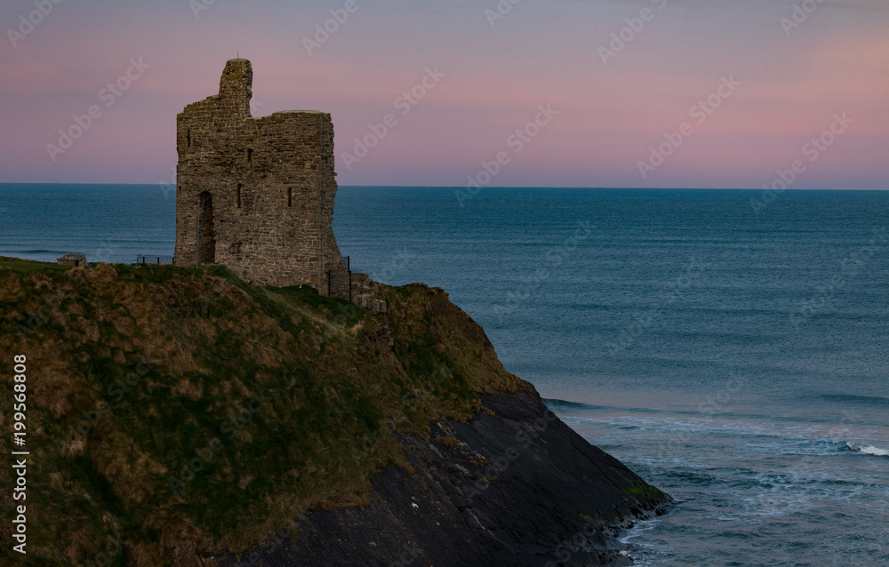 Castle ruins on the Atlantic coast of Ireland in the town of Ballybunion just before dawn light 