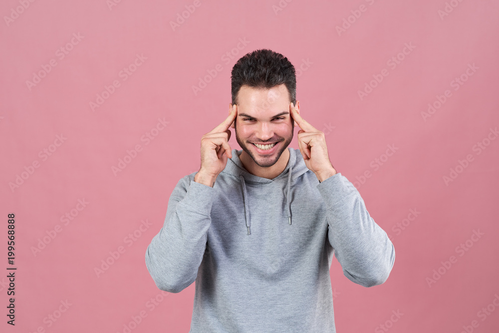 a happy smiling man presses his fingers to his temples in an attempt to concentrate and smiles widely. The concept of inspiration a happy smiling man presses his fingers to his temples in an attempt to concentrate and smiles widely. The concept of inspiration