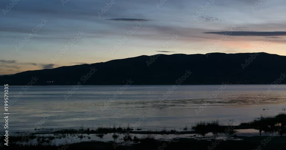 Utah Lake sunset mountain shore landscape pan. Fresh water lake west of Rocky Mountains in urban area of central Utah. Sport and recreation use. Beautiful mountain valley. Utah Lake sunset mountain shore landscape pan. Fresh water lake west of Rocky Mountains in urban area of central Utah. Sport and recreation use. Beautiful mountain valley.