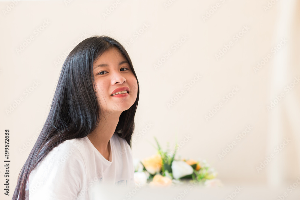 Education learning Concept: Closeup shot of Asian Happy Young woman student smiling Lughing looking at camera with blur of flower background in relax room in school college. Education learning Concept: Closeup shot of Asian Happy Young woman student smiling Lughing looking at camera with blur of flower background in relax room in school college.