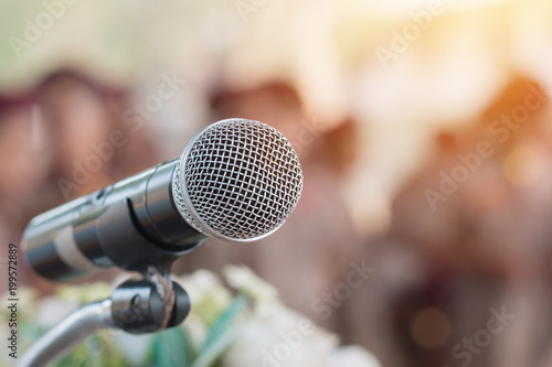 Microphones on abstract blurred of speech in seminar room, speaking conference hall light for presentation in exhibition event Background. Mic is transducer that convert sound into electrical signal.