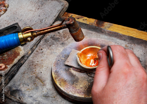 Close-up of gold melting with the help of a gasoline burner.
