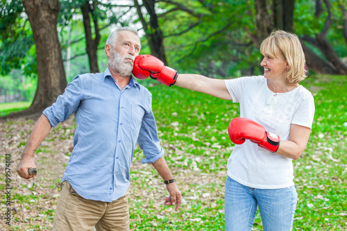 Happy funny senior couple boxer man and woman with red gloves in park © iammotos