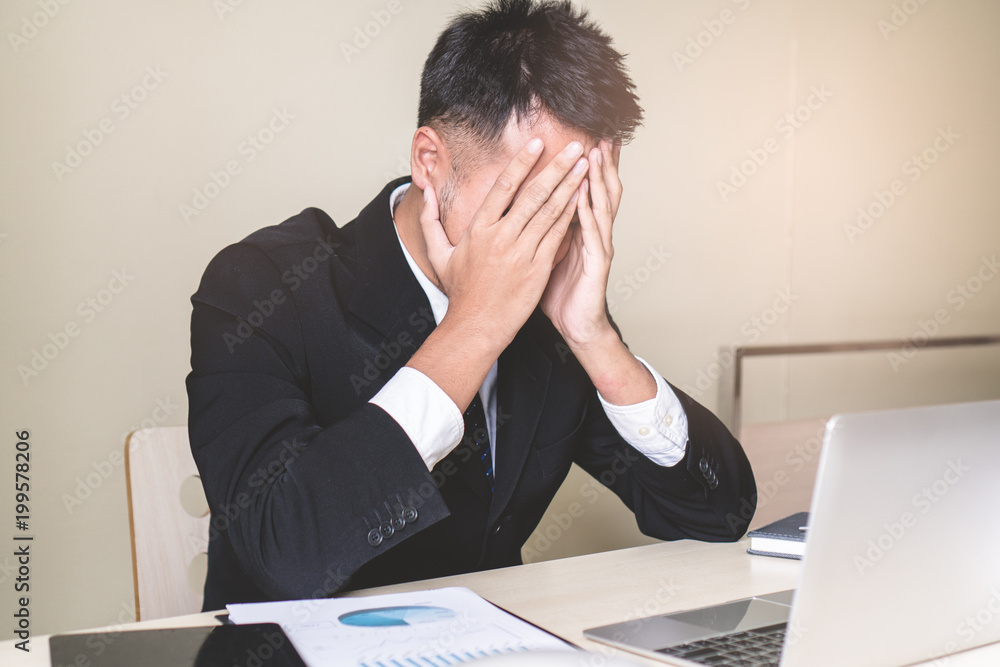Stressed Asian male employee sitting in the office tired after overwork all night. Stressed Asian male employee sitting in the office tired after overwork all night.