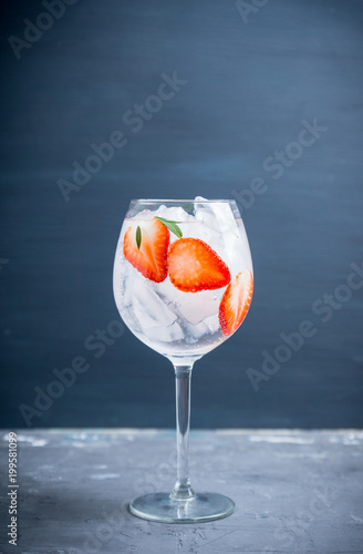 Gin with strawberry and ice in wine glass. Selective focus.