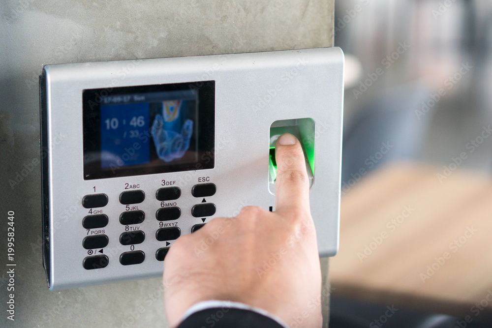 Employee scanning fingerprint record hours work time. Employee scanning fingerprint record hours work time.