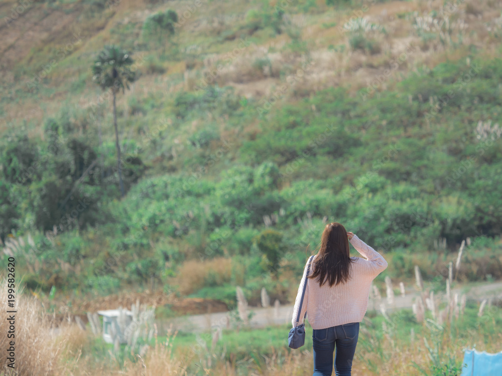 summer and asia travel concept from girl walking and see on country road with sky ,cloudy and wind turbine background