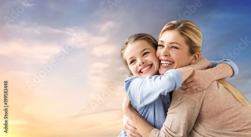 people and family concept - happy smiling mother hugging daughter over evening sky background