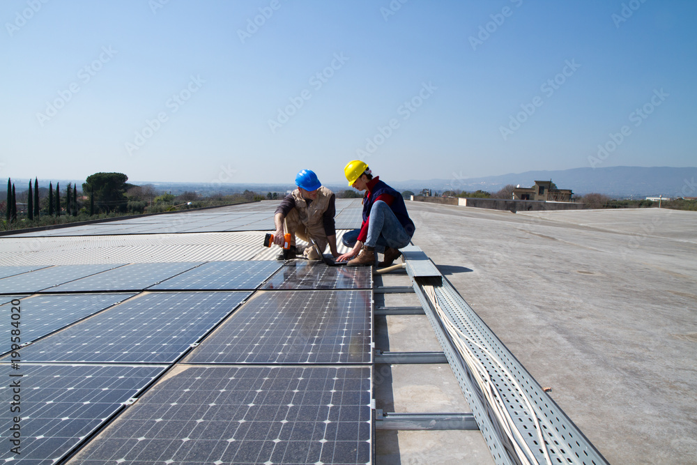 young engineer girl and an elderly skilled worker fitting a photovoltaic plant