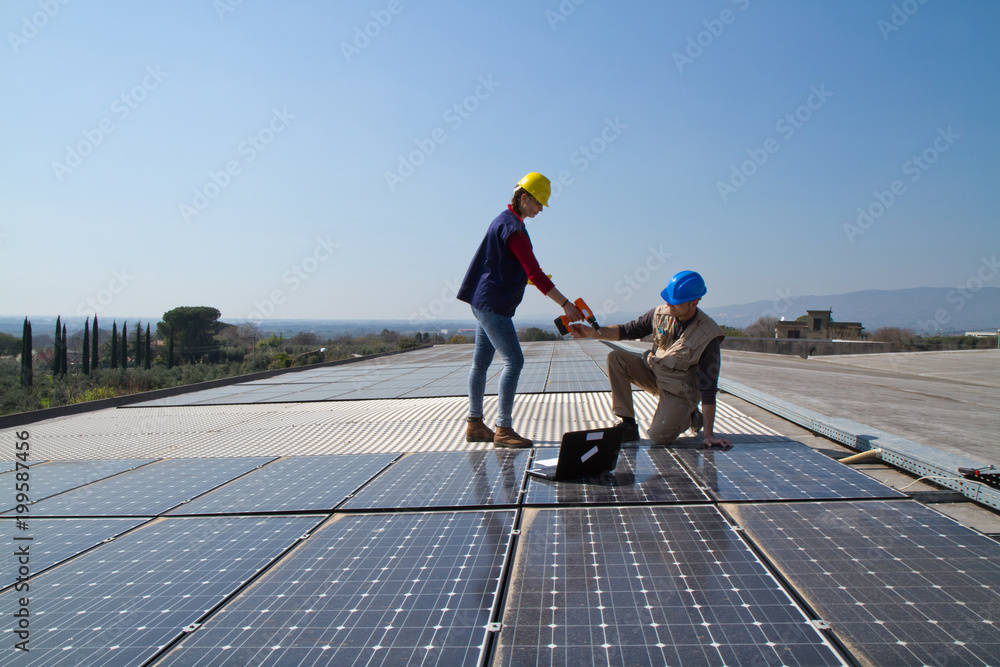young engineer girl and an elderly skilled worker fitting a photovoltaic plant