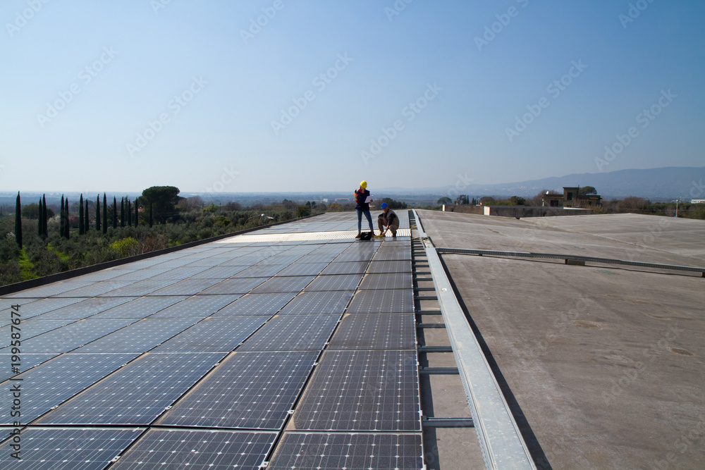 young engineer girl and an elderly skilled worker fitting a photovoltaic plant