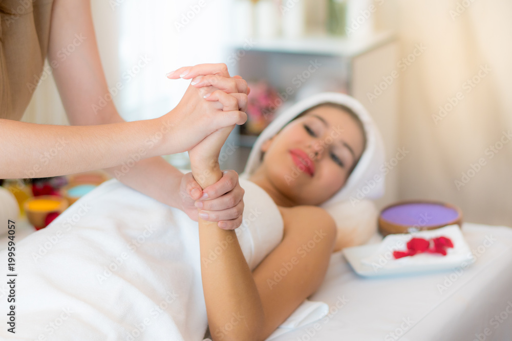 Young lady relaxing in spa with massage therapy. Masseur massaging client hand for heal from work day. p Young lady relaxing in spa with massage therapy. Masseur massaging client hand for heal from work day. p