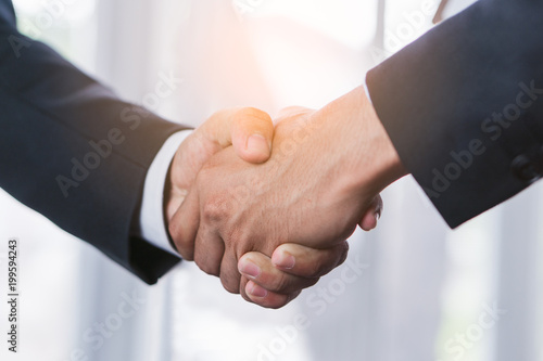Business partnership successful agreement deal concept. Close up hands two ceo of company shaking hands after signed  contract for being partner.