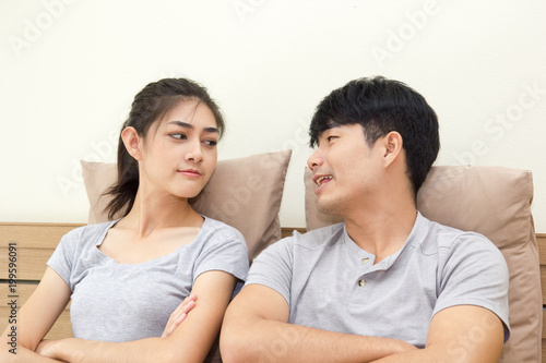 Smiling young couple looking at each other face on the bed.