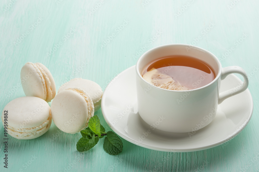 Tea with mint and lemon and white macaroons with mint Tea with mint and lemon and white macaroons with mint