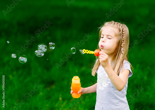 Little girl playing with soap bubbles.