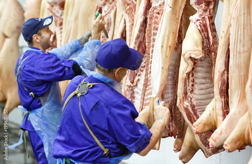 Photos Butcher cutting pork  at the meat manufacturing.