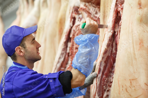 Butcher cutting pork  at the meat manufacturing. © davit85