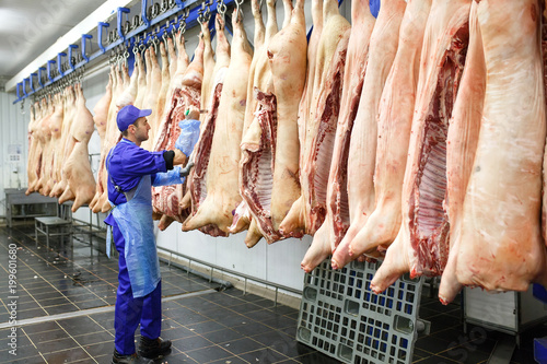 Schilderij op canvas Butcher cutting pork  at the meat manufacturing.