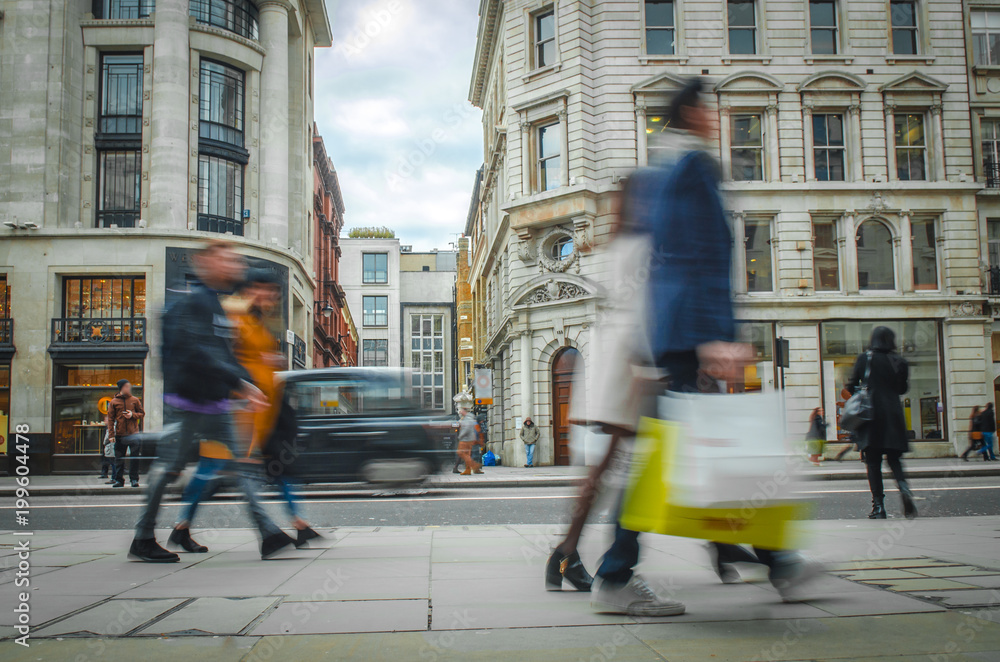 Motion blurred shoppers on busy high street carrying shopping bags - obrazy, fototapety, plakaty 